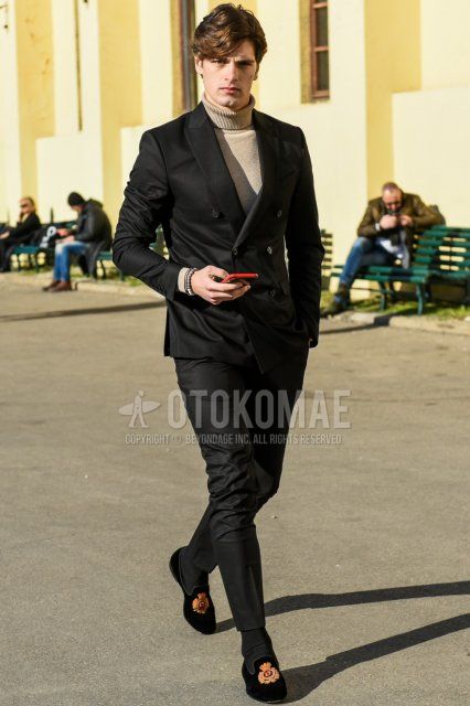 Men's spring and fall coordinate and outfit with solid beige turtleneck knit, solid dark gray socks, suede black loafer leather shoes, and solid black suit.