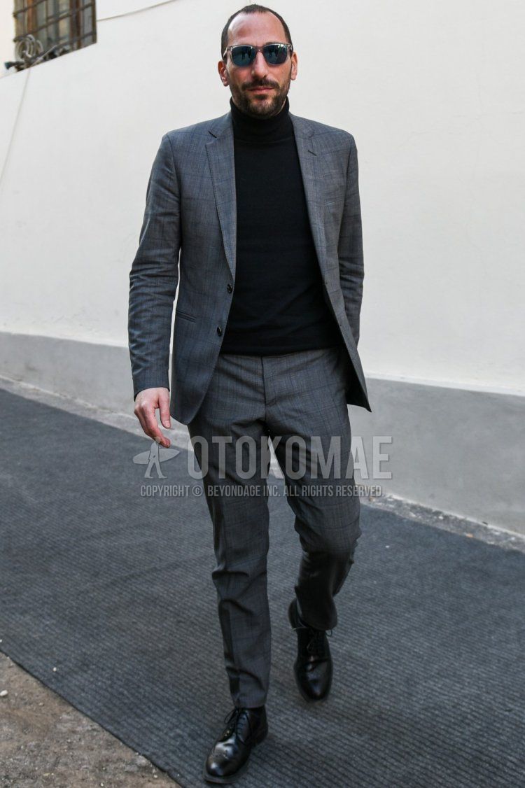 Men's spring and fall outfit with Wellington clear plain sunglasses, plain black turtleneck knit, black wingtip leather shoes, black brogue shoes leather shoes, and gray checked suit.
