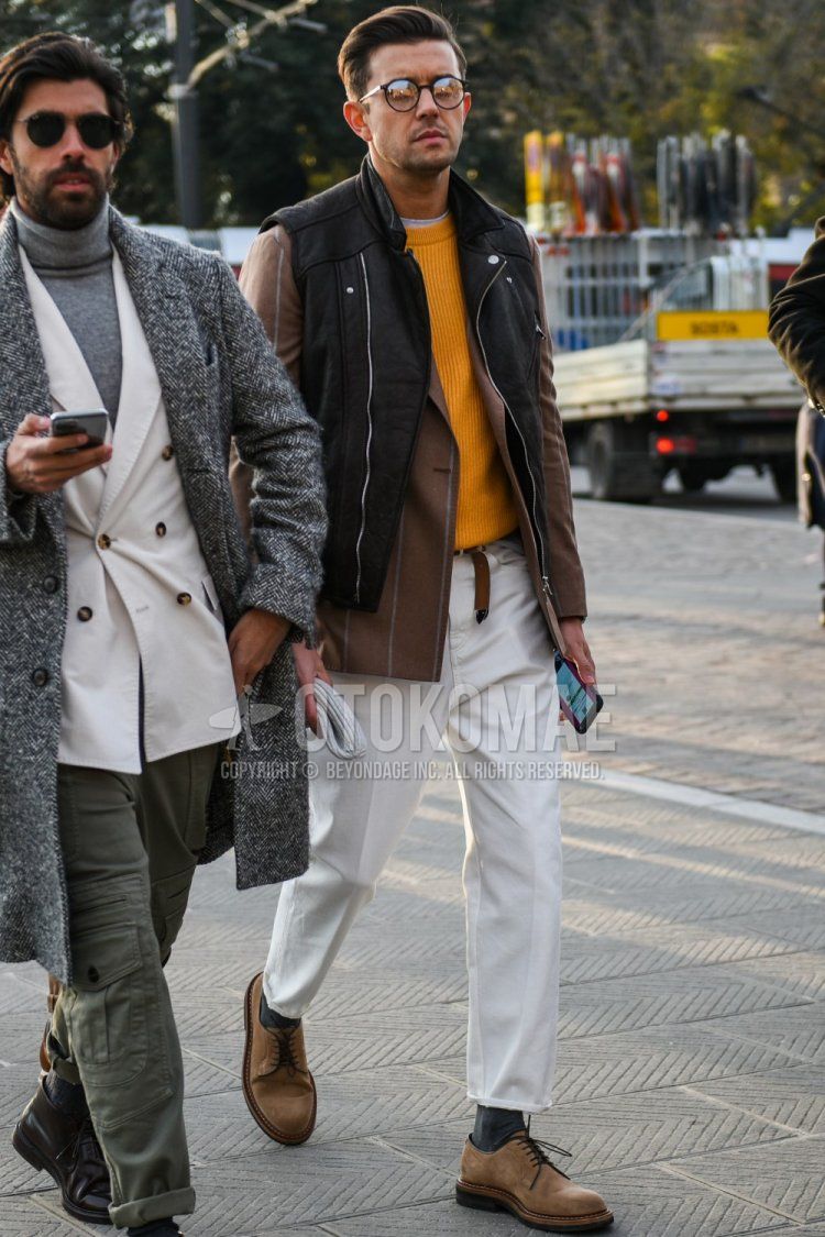 Men's fall/winter outfit with round plain black glasses, plain black casual vest, beige striped tailored jacket, plain yellow sweater, plain white cotton pants, plain white ankle pants, plain gray socks, suede beige plain toe leather shoes The outfit.