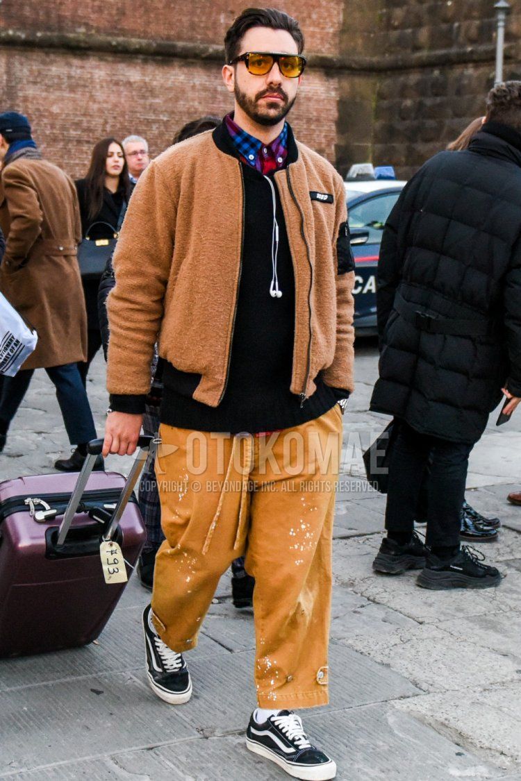 Winter men's coordinate and outfit with solid color sunglasses, solid color brown fleece jacket, solid color black sweater, red checked shirt, solid color brown wide pants, solid color brown cotton pants, solid color white socks, black low-cut sneakers by Vans.