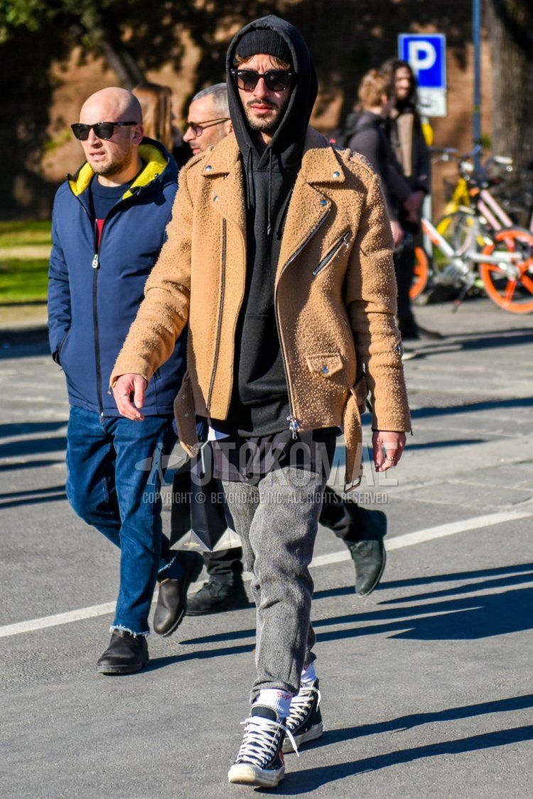 Solid black knit cap, Ray-Ban Wellington solid black sunglasses, solid beige rider's jacket, solid black hoodie, solid black T-shirt, solid gray sweatpants, Supreme one-point white socks, Converse All Star Comme des Garcons Play black high cut sneakers for men's fall and winter outfits.