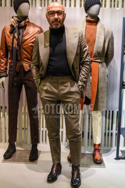 Men's spring and fall coordinate and outfit with brown tortoiseshell glasses, dark gray plain turtleneck knit, brown/black boots, and beige check suit.