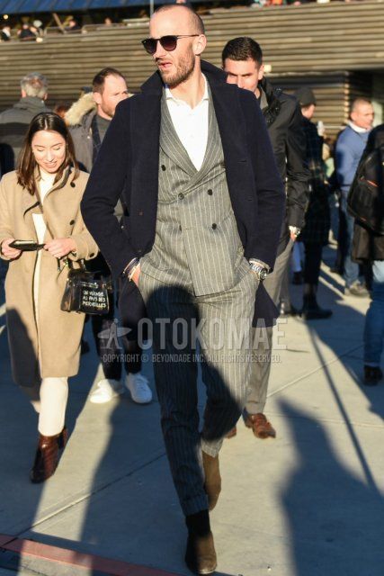 Men's fall/winter coordinate and outfit with plain black sunglasses, plain black chester coat, plain white shirt, brown side gore boots, and gray striped suit.