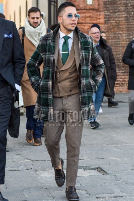 Men's fall/winter outfit and outfit with plain gold sunglasses, green checked chester coat, plain beige gilet, plain white shirt, brown coin loafer leather shoes, plain beige suit, and plain green tie.