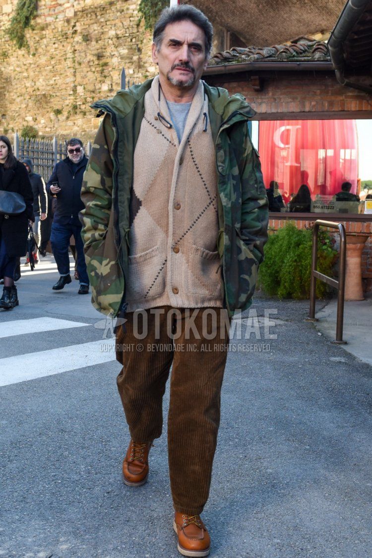 Men's fall/winter coordinate and outfit with olive green camouflage mountain parka, beige top/inner cardigan, plain gray t-shirt, plain brown winter pants (corduroy, velour), brown work boots.