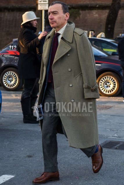 Men's fall/winter outfit with solid beige trench coat, solid navy tailored jacket, white checked shirt, solid gray slacks, solid navy socks, brown u-tip leather shoes, and solid red tie.