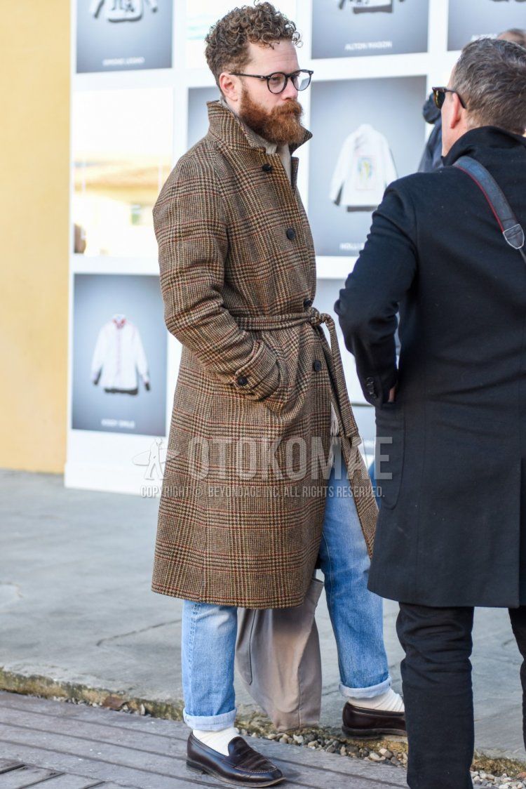 Men's fall/winter coordinate and outfit with plain black glasses, beige checked stainless steel collar coat, beige checked belted coat, solid light blue denim/jeans, solid white socks, brown coin loafer leather shoes, and solid beige tote bag.