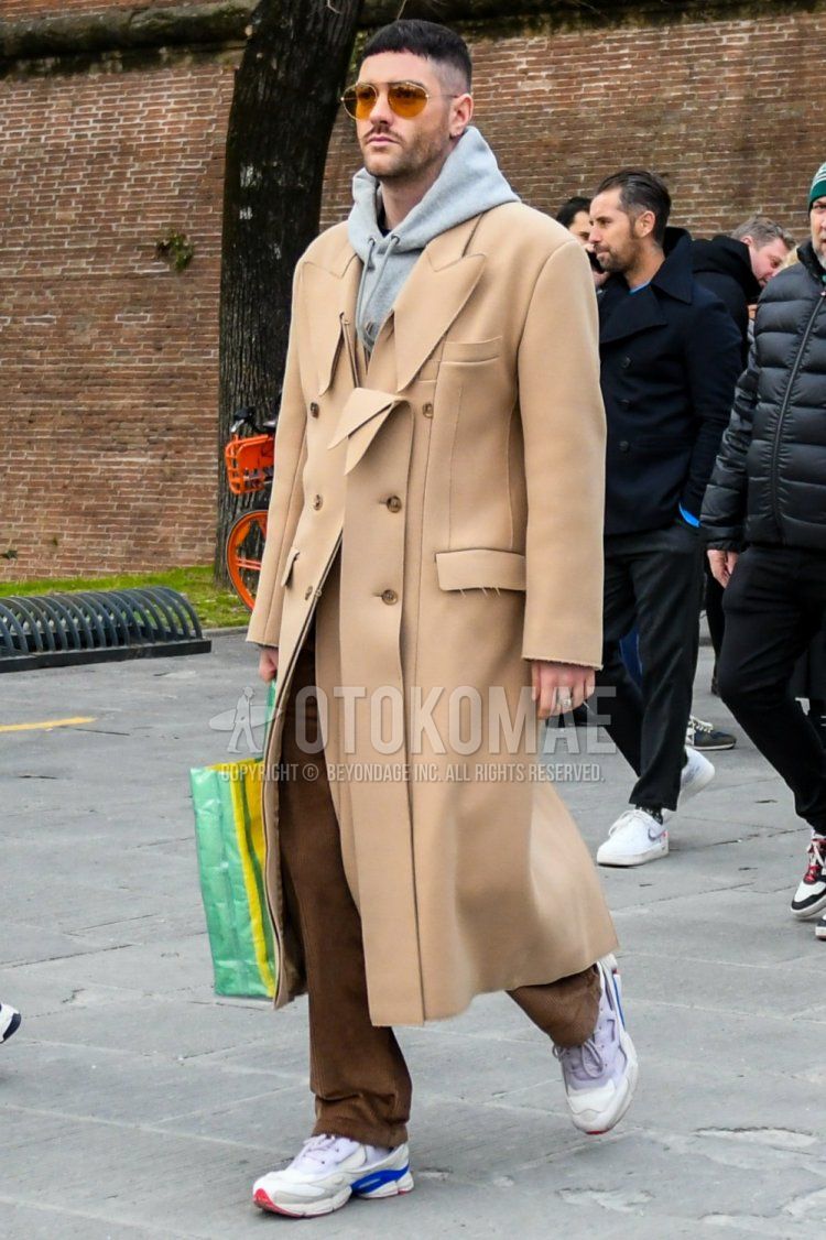 Men's fall/winter coordinate and outfit with solid color sunglasses, solid color beige chester coat, solid color gray hoodie, solid color brown cotton pants, and white low-cut sneakers.