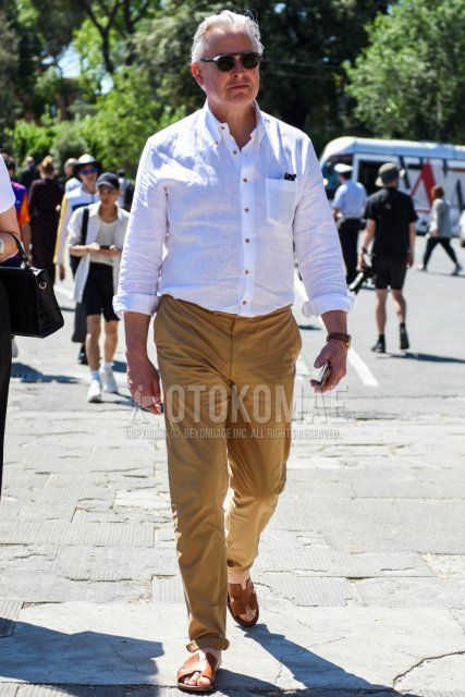Men's spring/summer coordinate and outfit with plain gray sunglasses, plain white linen shirt, plain beige chinos, and brown leather sandals by Hermes.