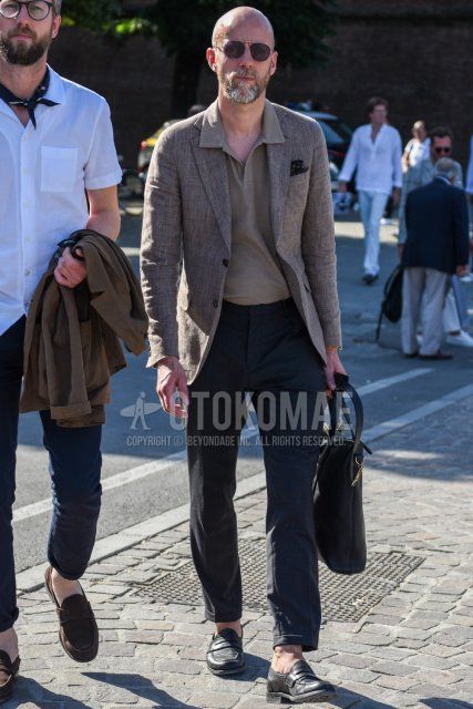 Spring/summer/fall men's outfit with plain silver sunglasses, plain linen brown tailored jacket, plain beige polo shirt, plain dark gray slacks, plain dark gray ankle pants, black coin loafer leather shoes, and plain black briefcase/handbag. Outfit.