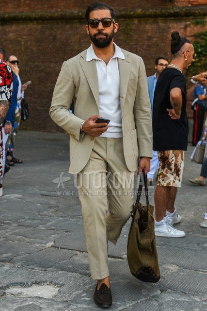 Men's spring, summer, and fall coordination and outfit with square plain black sunglasses, knit plain white polo shirt, suede brown tassel loafer leather shoes, plain brown tote bag, and plain beige suit.