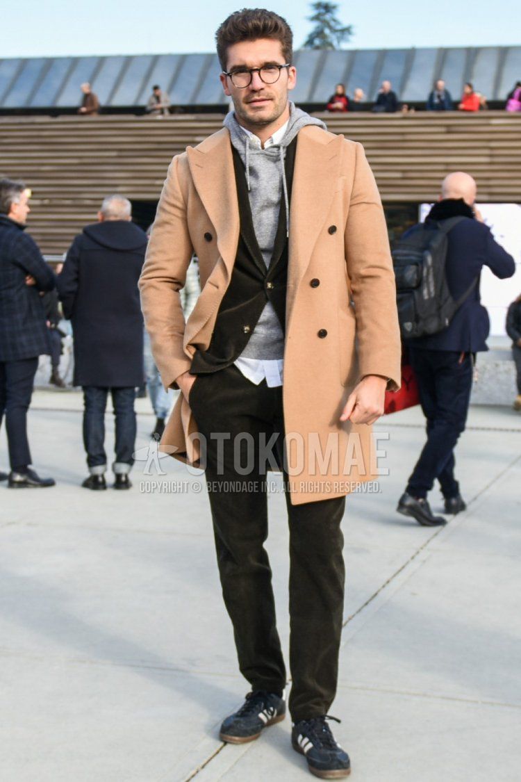 Men's winter coordinate and outfit with brown tortoiseshell glasses, plain beige chester coat, knit plain gray hoodie, plain white shirt, plain black socks, Adidas navy low-cut sneakers, and plain olive green suit.