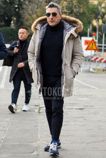 Men's fall/winter outfit with plain silver/black sunglasses, plain white down jacket, plain white hooded coat, plain navy turtleneck knit, plain gray slacks, plain gray ankle pants, plain navy socks, and navy low-cut sneakers. Outfit.