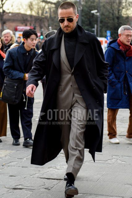 Men's fall/winter coordinate and outfit with teardrop gold solid sunglasses, solid black trench coat, solid black turtleneck knit, solid black socks, and solid gray suit.