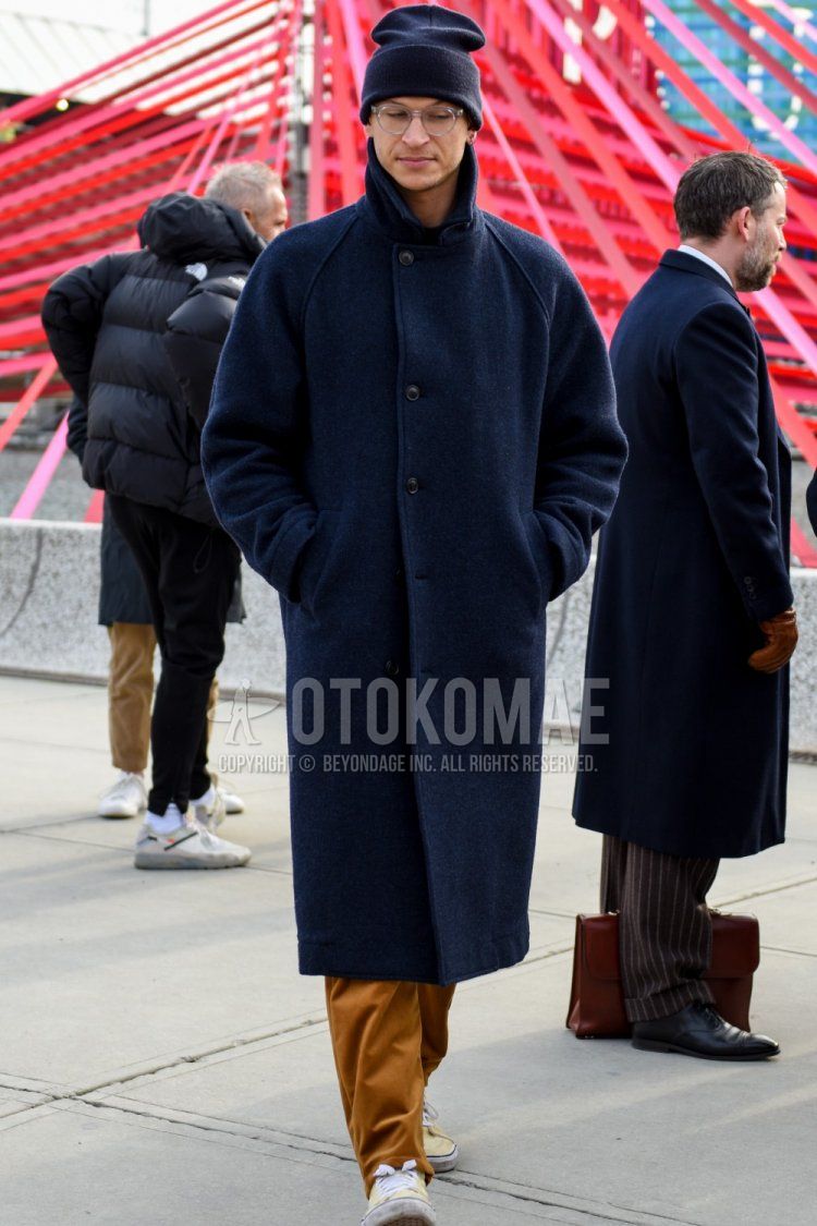 Men's fall/winter coordinate and outfit with plain navy knit cap, plain silver glasses, plain navy stainless steel collar coat, plain beige chinos, and beige low-cut sneakers.