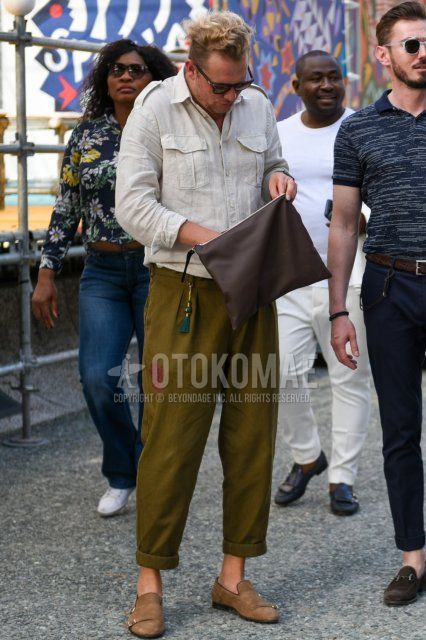 Men's summer coordinate and outfit with plain black sunglasses, plain white shirt, plain olive green beltless pants, beige loafer leather shoes, and plain brown clutch bag/second bag/drawstring.
