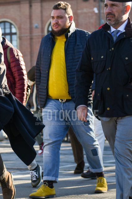 Men's fall/winter outfit with dark gray solid tailored jacket, dark gray solid down jacket, yellow solid sweater, Gucci black solid leather belt, light blue solid denim/jeans, black socks socks, suede yellow wingtip leather shoes.