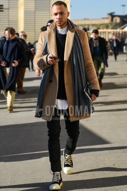 Men's fall/winter coordinate/outfit with plain gray scarf/stall, plain beige chester coat, plain black sweater, plain white shirt with band collar, plain black denim/jeans, and black high-cut sneakers.