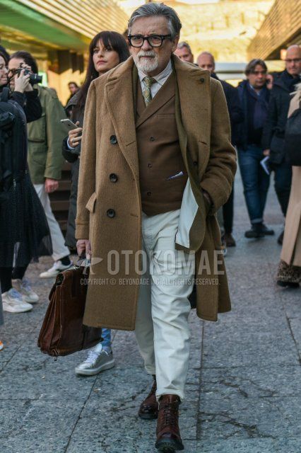 Men's fall/winter coordinate and outfit with plain black glasses, plain beige Ulster coat, plain beige tailored jacket, plain brown gilet, plain beige shirt, plain white cotton pants, brown boots, and beige necktie tie.