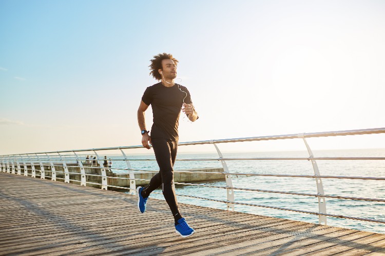 attractive-male-athlete-wearing-stylish-black-sport-clothing-and-blue-sneakers-figure-of-man-athlete-doing-cardio-running- exercises-on-sunny-summer-morning