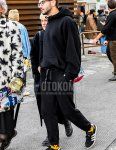 Men's spring/fall/winter coordinate and outfit with solid color glasses, solid color black hoodie, solid color black sweatpants, solid color yellow socks, and black low-cut Adidas sneakers.