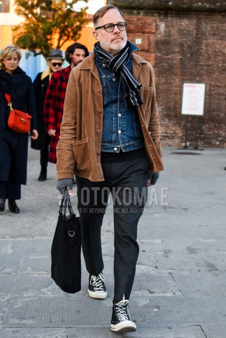 Solid black glasses, gray striped scarf/stall, solid brown coveralls, solid blue denim jacket, solid gray slacks, solid gray cropped pants, Converse All Star black high cut sneakers, solid black briefcase/handbag Men's fall/winter coordinate/outfit.