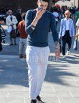 Men's spring, summer, and fall coordination and outfit with plain blue sweater, plain white/gray sweatpants, and black low-cut sneakers.