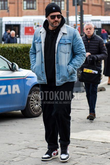 Men's fall/winter coordinate and outfit with black one-pointed knit cap, solid black sunglasses with teardrops, solid blue denim jacket, solid black hoodie, solid navy winter pants (corduroy, velour), Nike black, white and red high-cut sneakers.