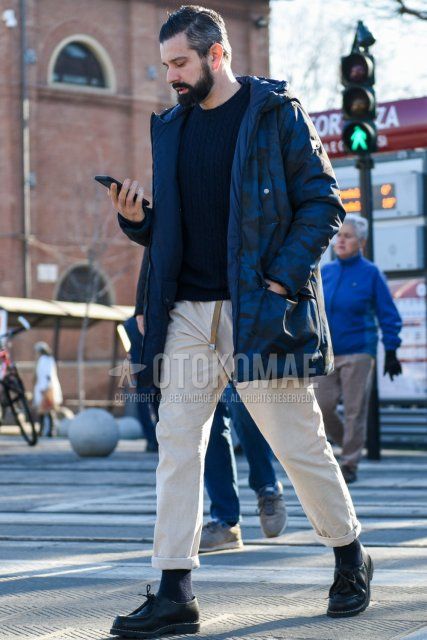 Men's fall/winter outfit with blue camouflage hooded coat, solid navy sweater, solid beige winter pants (corduroy, velour), dark gray solid socks, and black Tyrolean leather shoes.