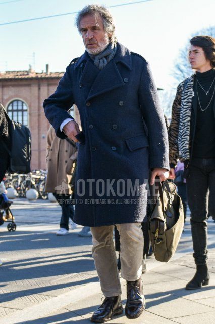 Men's fall/winter coordinate/outfit with plain gray scarf/stall, plain navy trench coat, solid beige winter pants (corduroy,velour), brown chukka boots, solid beige briefcase/handbag.