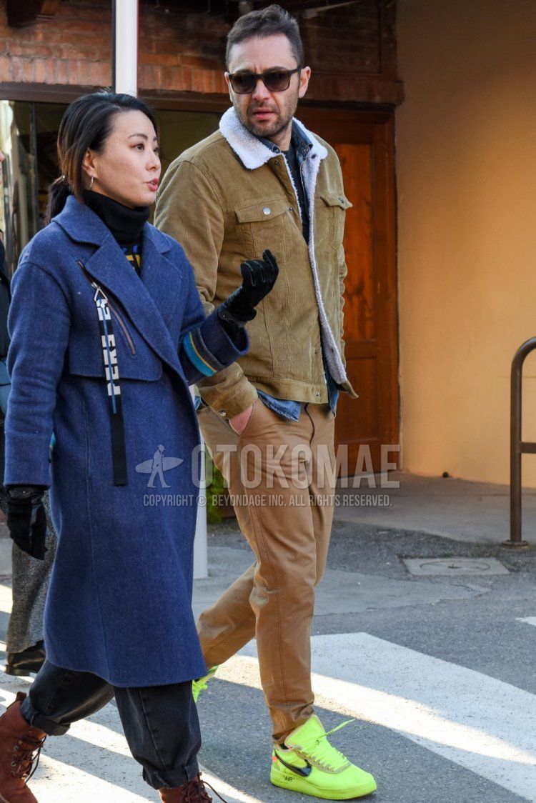 Men's fall/winter coordinate and outfit with brown tortoiseshell sunglasses, solid beige trucker jacket, solid blue denim/chambray shirt, solid beige chinos, and Nike Off White Zaten Air Force 1 yellow low cut sneakers.