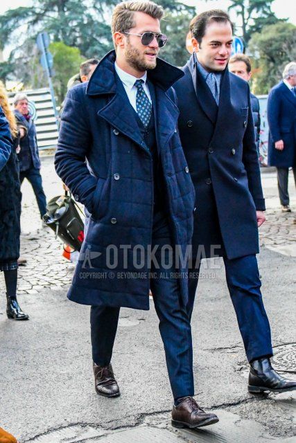 Men's fall/winter outfit with plain sunglasses, plain navy down jacket, navy striped slacks, brown straight tip leather shoes, plain navy three-piece suit and navy small print tie.