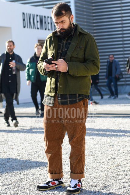 Men's fall/winter coordinate and outfit with olive green solid shirt jacket, dark gray check shirt, brown solid winter pants (corduroy,velour), and New Balance white/black low-cut sneakers.
