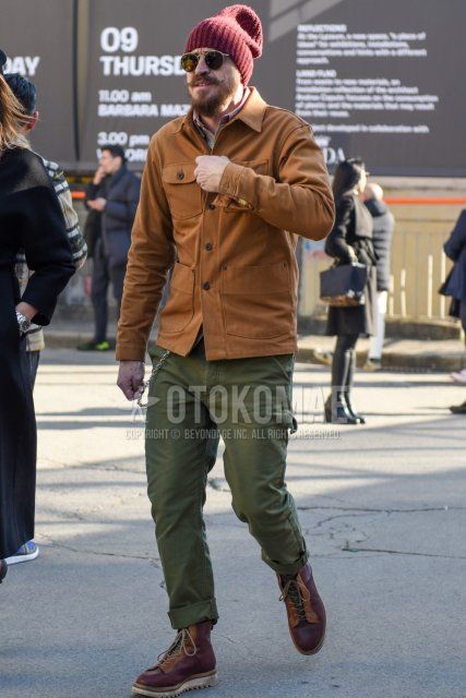 Men's fall/winter coordinate and outfit with red solid knit cap, Ray-Ban gold solid sunglasses, beige solid shirt jacket, pink solid shirt, olive green solid chinos, and brown boots.