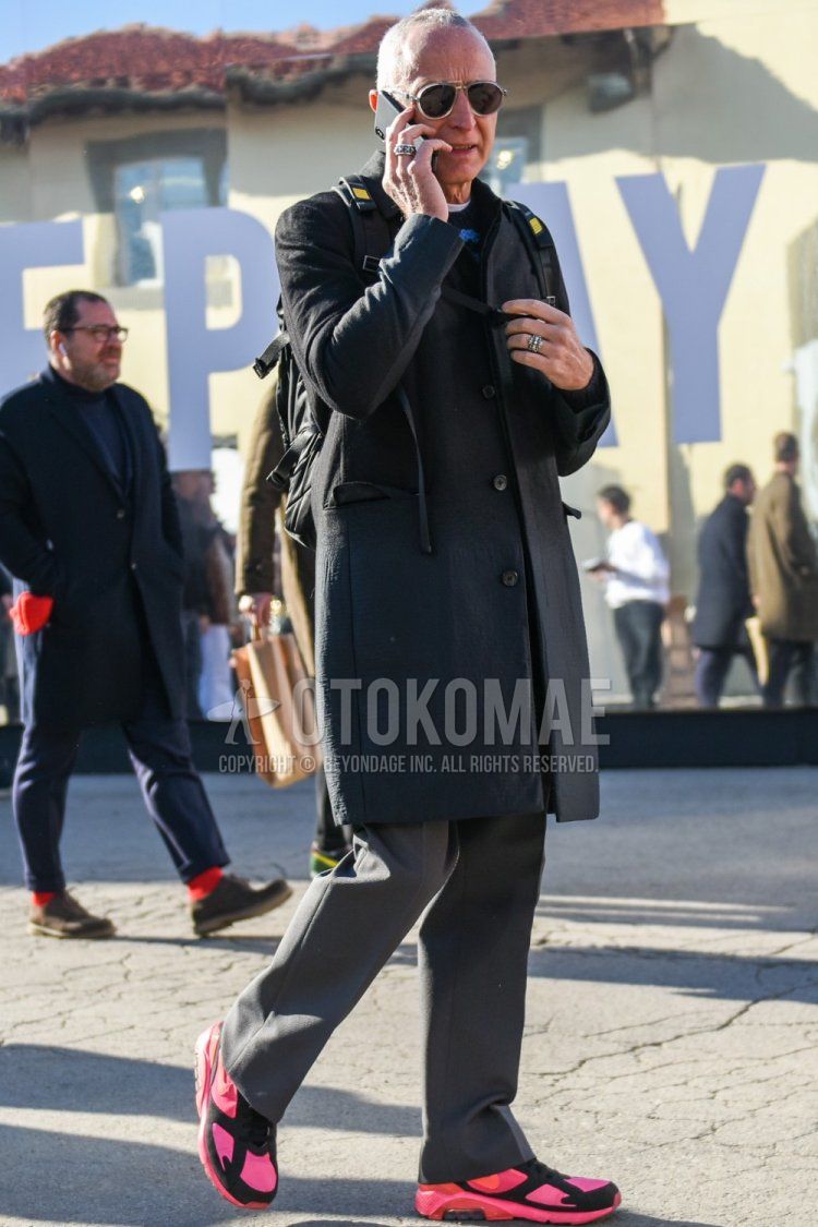 Men's fall/winter coordinate and outfit with clear solid sunglasses, solid gray chester coat, solid black sweater, solid gray slacks, and Nike Comme des Garcons Homme Prus Air Max 180 pink low-cut sneakers.