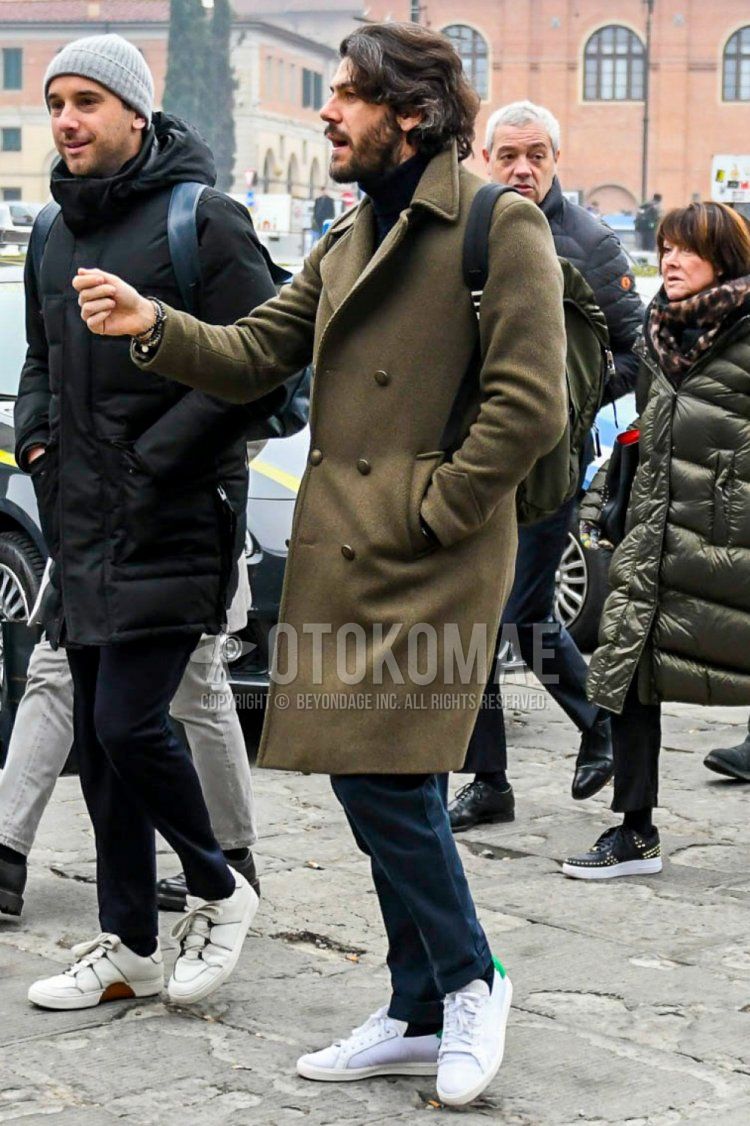 Winter men's coordinate and outfit with olive green solid color Ulster coat, black solid color turtleneck knit, navy solid color chinos, black solid color socks and white low-cut sneakers.