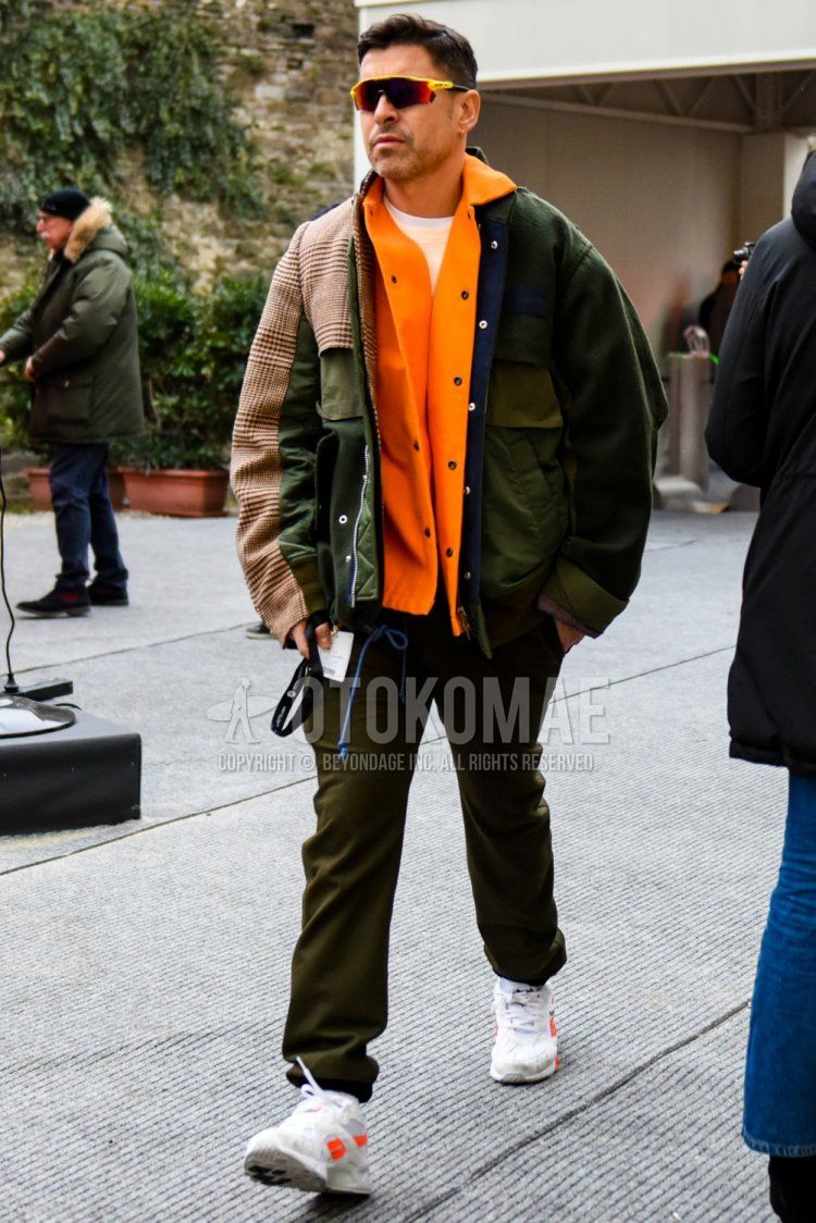 Yellow-orange solid sunglasses, Sakai olive green-beige solid outerwear, Sakai orange solid coach jacket, white solid T-shirt, beige solid trainers, olive green solid easy pants, Reebok Aztrek white low-cut sneakers. Men's fall/winter outfits and outfits.