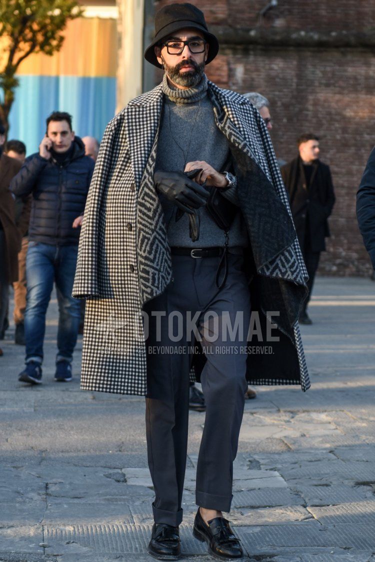 Men's fall/winter outfit/coordination with plain black hat, plain black glasses, white/black checked chester coat, plain gray turtleneck knit, plain black leather belt, plain gray slacks, and black tassel loafer leather shoes.