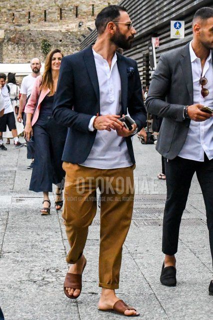 Men's spring/summer coordinate and outfit with plain sunglasses, plain navy tailored jacket, plain white shirt, plain brown cotton pants, plain brown chinos, and brown shower sandals.