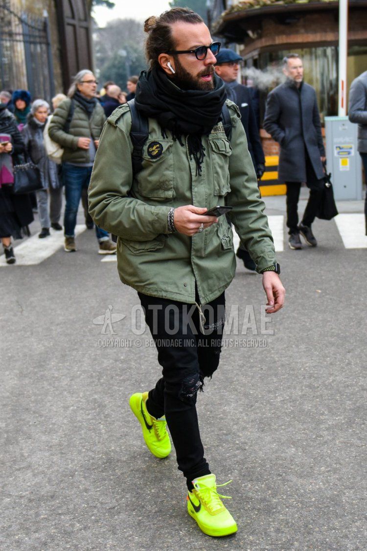Winter men's coordinate and outfit with plain sunglasses, plain black scarf/stall, plain olive green M-65, plain black damaged jeans, and Nike yellow low-cut sneakers.