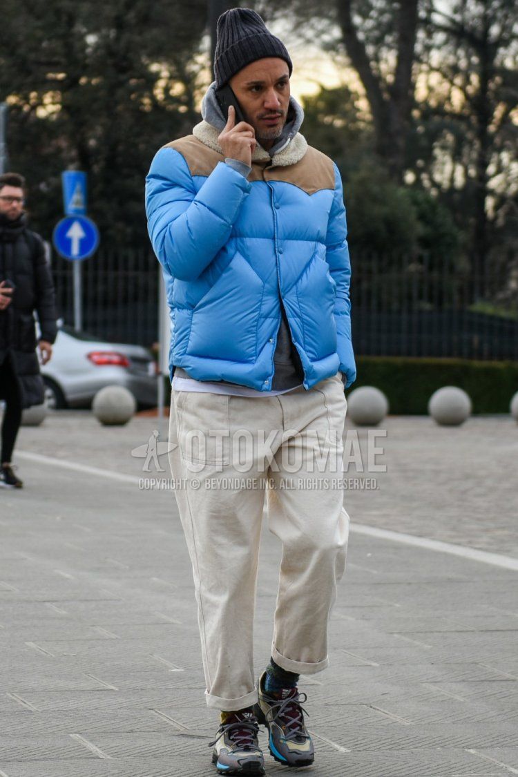Men's fall/winter coordinate and outfit with solid gray knit cap, solid blue down jacket, solid gray hoodie, solid white cotton pants, multi-colored socks socks, and multi-colored low-cut sneakers.