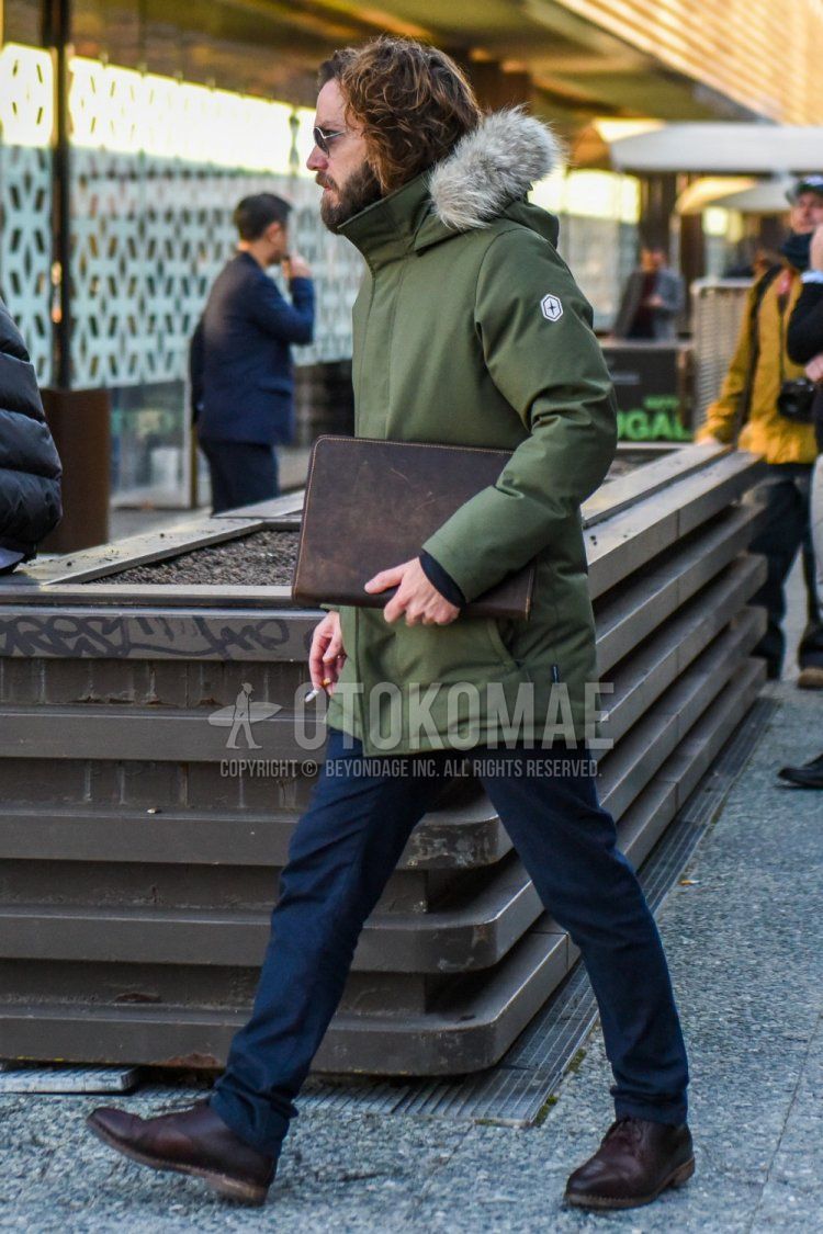 Winter men's coordinate and outfit with plain silver sunglasses, plain olive green down jacket, plain navy chinos, brown straight tip leather shoes, and plain brown clutch/second bag/drawstring bag.