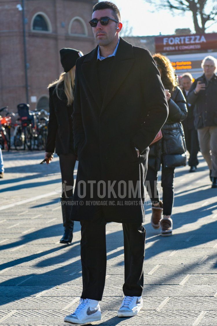 Men's fall/winter coordinate and outfit with brown tortoiseshell sunglasses from Boston, plain black chester coat, plain black sweater, blue striped shirt, dark gray plain slacks, and white high-cut Nike sneakers.