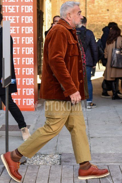 Men's fall/winter coordinate and outfit with multi-colored scarf/stall, solid brown shirt jacket, solid beige chinos, solid beige cropped pants, and brown leather shoes.