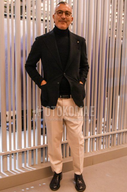 Men's spring and fall coordinate and outfit with brown tortoiseshell glasses, plain black tailored jacket, plain black turtleneck knit, plain black leather belt, plain white cotton pants, and black straight tip leather shoes.