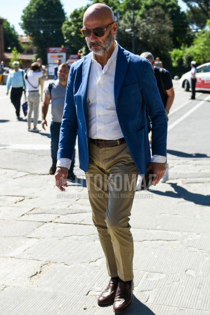 Men's spring, summer, and fall coordinate and outfit with brown tortoiseshell sunglasses, plain navy tailored jacket, plain white shirt, plain brown leather belt, plain beige chinos, plain black socks, and brown coin loafer leather shoes.