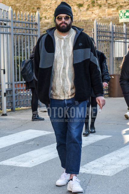 Solid black knit cap, beige tortoiseshell sunglasses, Nike solid black/gray fleece jacket, beige top/inner cardigan, solid blue denim/jeans, solid blue ankle pants, Reebok Club Sea white low-cut sneakers for fall/winter Men's Codes and Outfits.