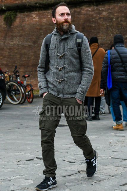 Men's fall/winter coordinate and outfit with gray check duffle coat, olive green solid color cargo pants, and New Balance black low-cut sneakers.