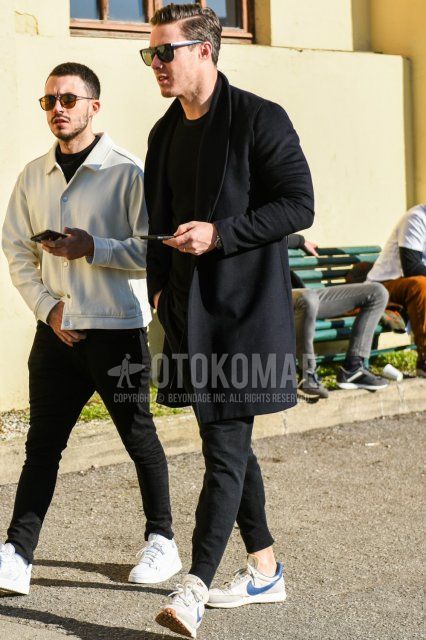 Men's fall/winter coordinate and outfit with plain black sunglasses, plain black chester coat, plain black sweater, plain black jogger pants/ribbed pants, and Nike gray low-cut sneakers.