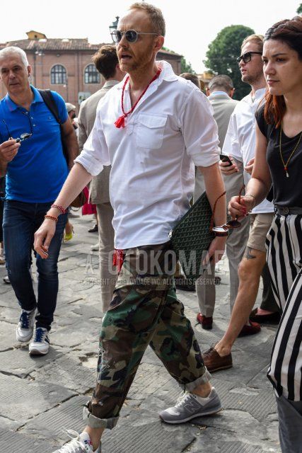 Men's spring/summer/autumn coordinate and outfit with plain silver/black sunglasses, plain white shirt, multi-colored camouflage cotton pants, multi-colored camouflage cargo pants, New Balance gray low-cut sneakers, and Goyard black bag clutch/second bag/drawstring.